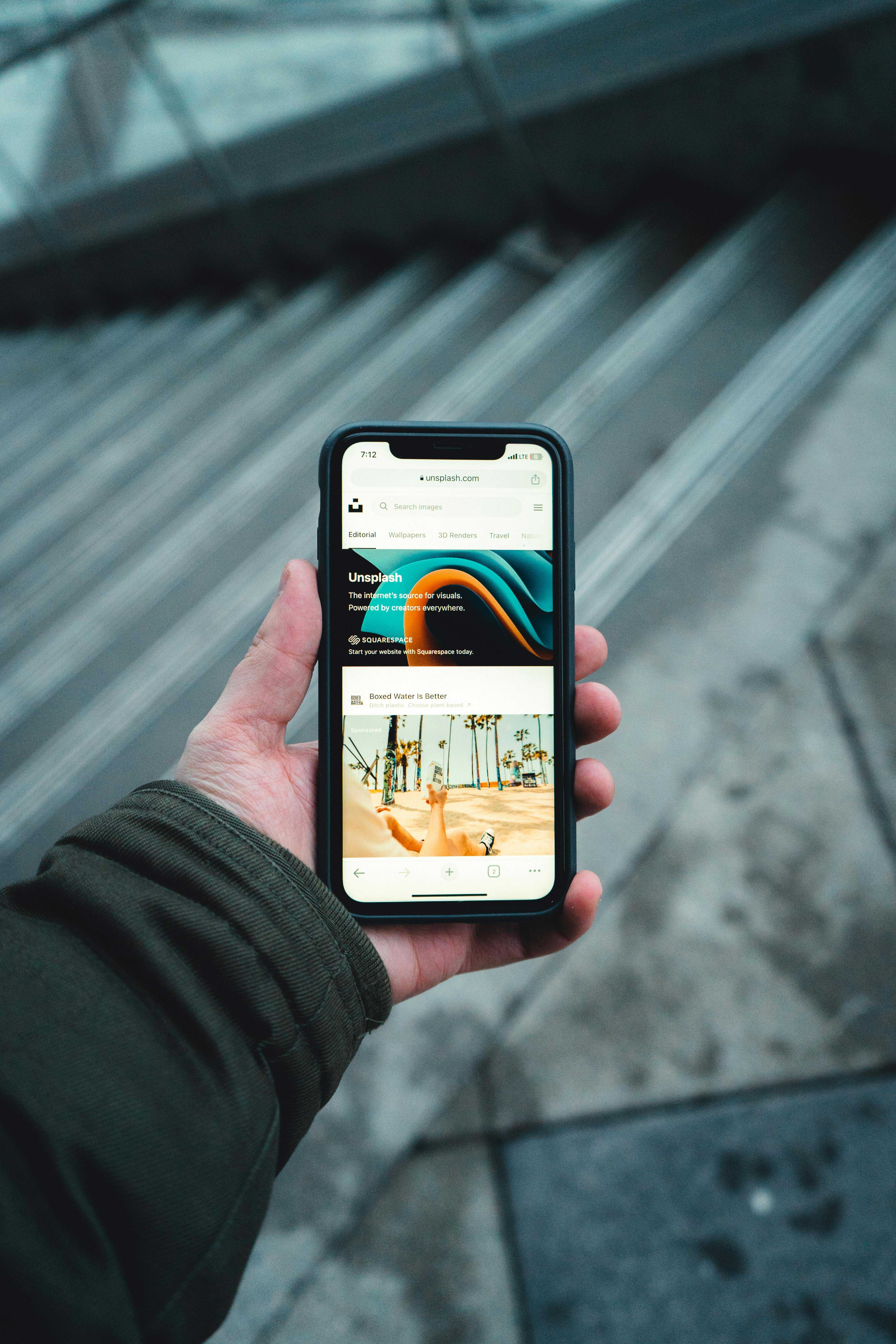 Person holding a phone showcasing a mobile-first web design