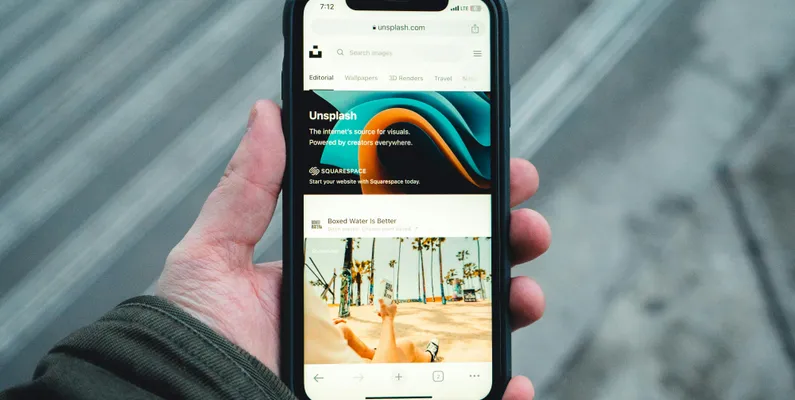 Person holding a phone showcasing a mobile-first web design