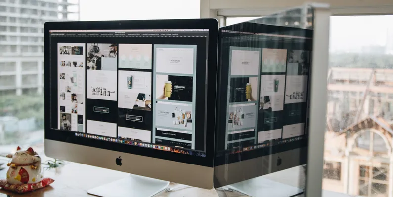 A computer monitor displaying different stages of a website's redesign